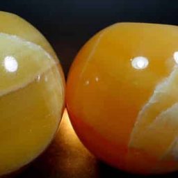 Orange Calcite Tea Light Candle Holder in the shape of a ball or sphere