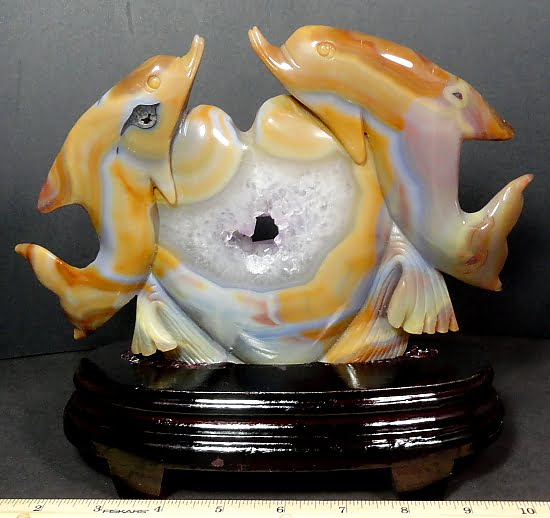 Dolphins caressing a heart carved from Agate with Amethyst center